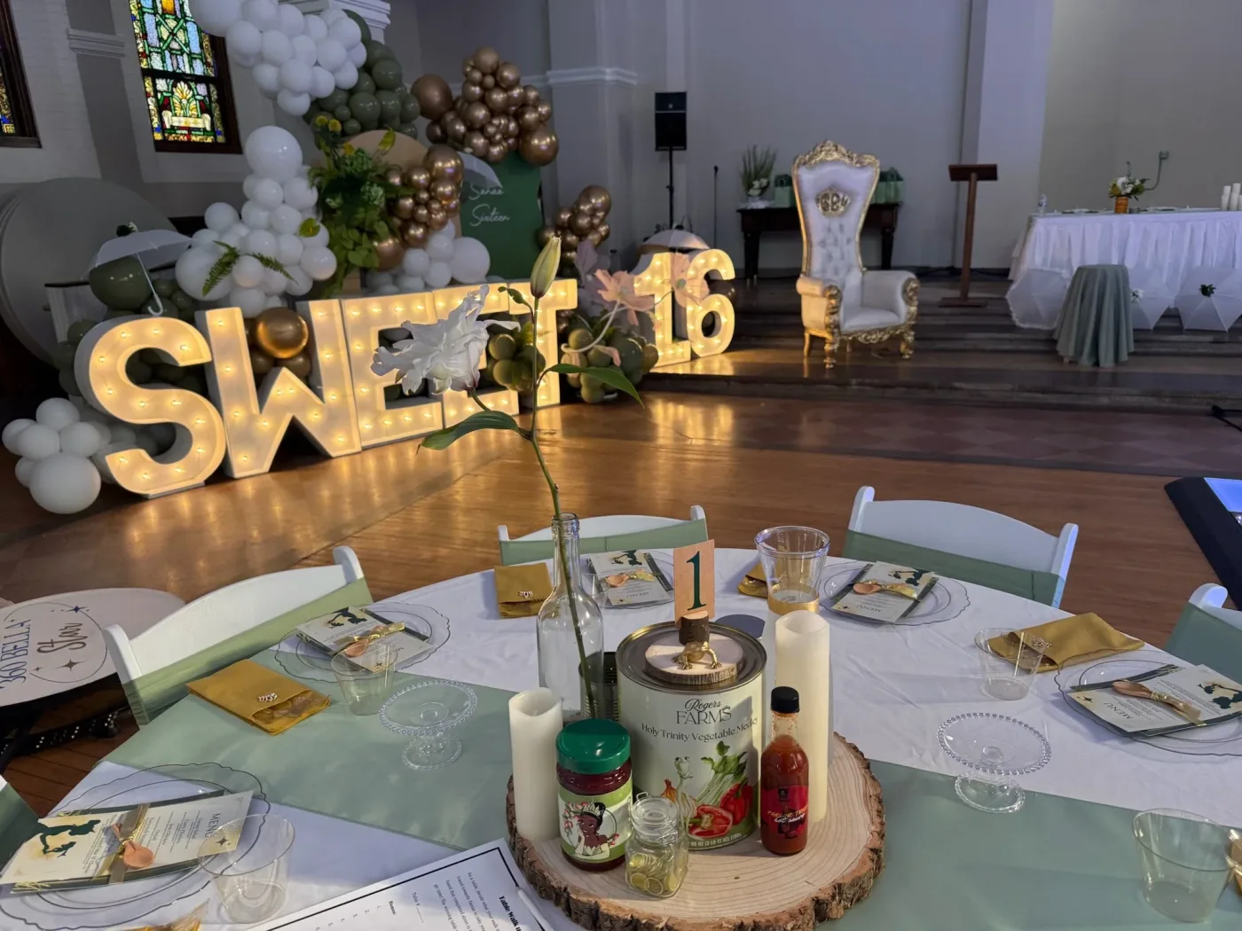 A Sweet 16 celebration table at Dresden Castle, with gold lettering and flowers
